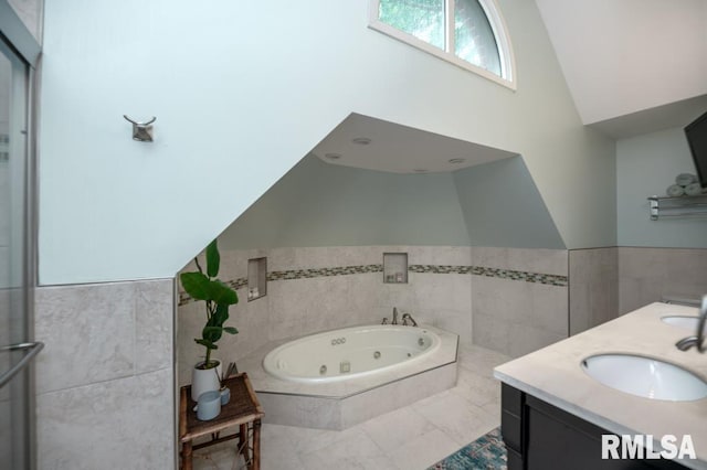 408 W Ravinwoods Rd, Peoria, IL 61615 - full bathroom with a tub with jets, high vaulted ceiling, tile walls, double vanity, and a wainscoted wall