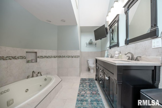 408 W Ravinwoods Rd, Peoria, IL 61615 - bathroom with tile walls, a tub with jets, double vanity, wainscoting, and tile patterned flooring