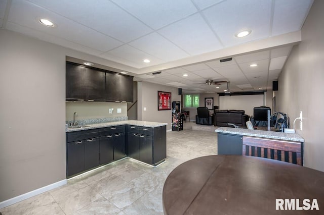 408 W Ravinwoods Rd, Peoria, IL 61615 - kitchen featuring a ceiling fan, recessed lighting, a paneled ceiling, dark cabinets, and open floor plan