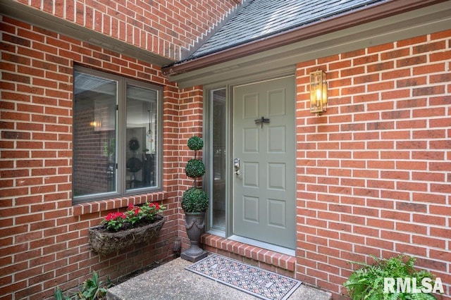 408 W Ravinwoods Rd, Peoria, IL 61615 - view of exterior entry featuring brick siding and a shingled roof