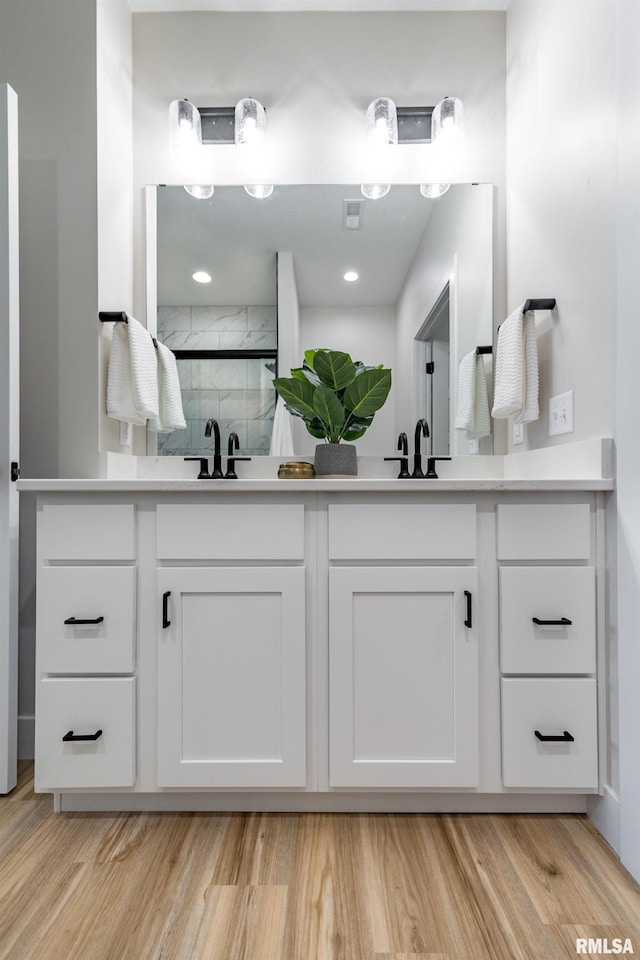 bathroom featuring walk in shower, vanity, and hardwood / wood-style flooring