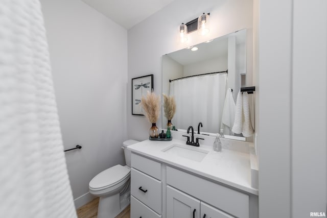 bathroom featuring wood-type flooring, vanity, and toilet