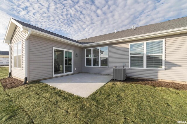 back of property with central air condition unit, a yard, and a patio area