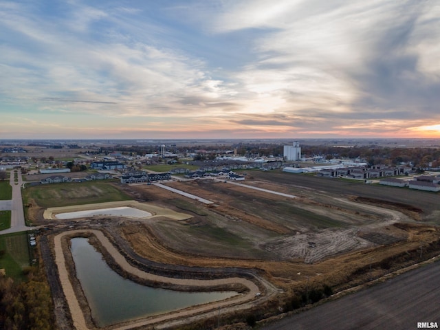 aerial view at dusk featuring a water view