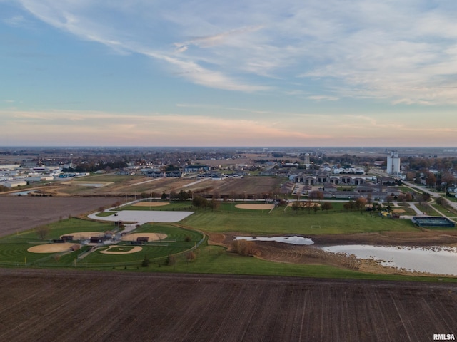 aerial view at dusk featuring a water view