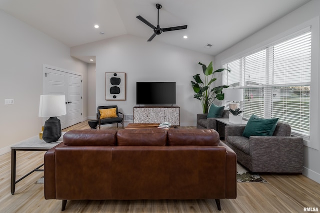 living room with lofted ceiling, ceiling fan, and light hardwood / wood-style flooring