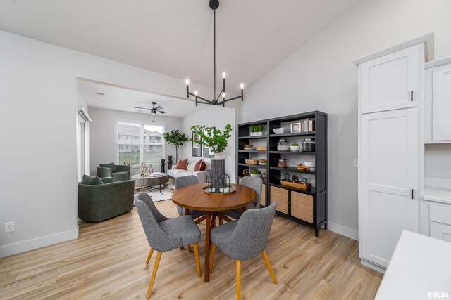 361 E Donahue St, Eldridge, IA 52748 - dining space with a chandelier, light wood-style flooring, vaulted ceiling, and baseboards