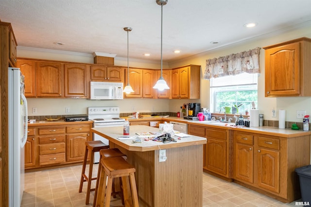 kitchen featuring white appliances, sink, light tile floors, hanging light fixtures, and a center island