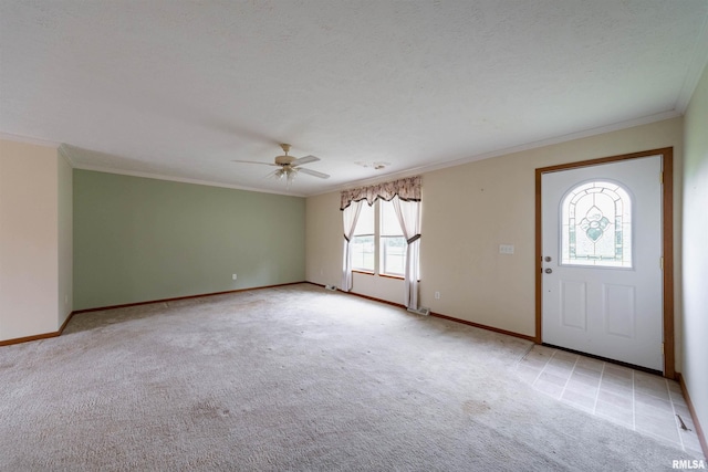 foyer entrance featuring light colored carpet, ornamental molding, and ceiling fan