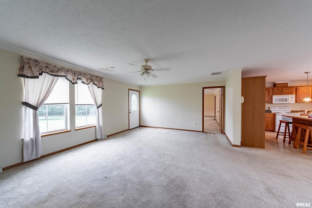 carpeted empty room with ceiling fan, a textured ceiling, and ornamental molding