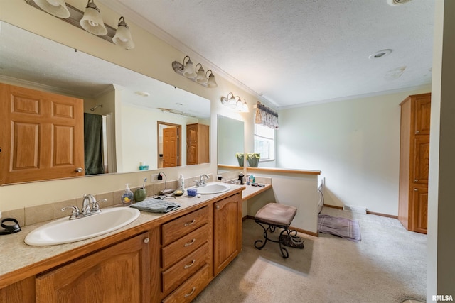 bathroom with double sink vanity, ornamental molding, and a textured ceiling