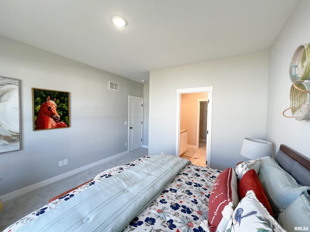 carpeted bedroom featuring ensuite bath