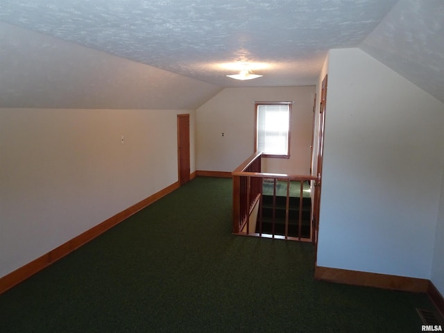 bonus room with carpet flooring, vaulted ceiling, a textured ceiling, and baseboards