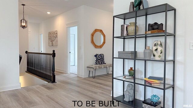 corridor with recessed lighting, an upstairs landing, wood finished floors, a chandelier, and baseboards