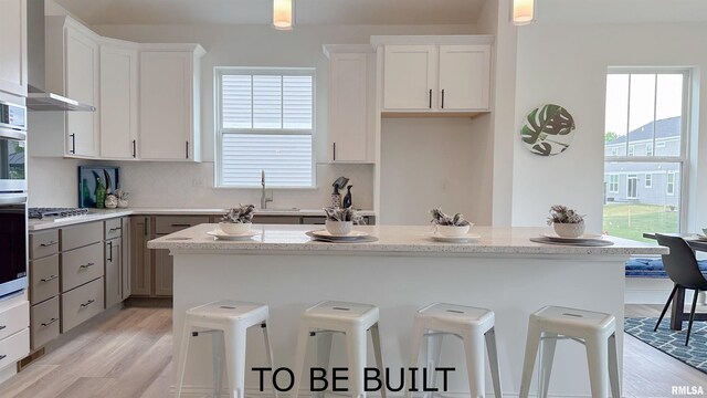 kitchen with tasteful backsplash, a wealth of natural light, a sink, and a kitchen breakfast bar