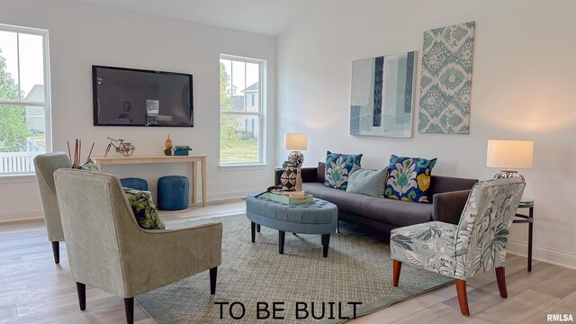 living area featuring baseboards, vaulted ceiling, and wood finished floors