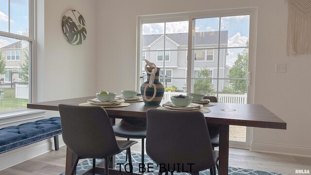 dining space featuring baseboards and light wood finished floors