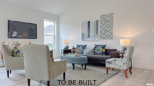 living room featuring vaulted ceiling, wood finished floors, and baseboards