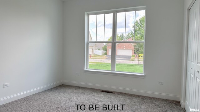 carpeted spare room featuring visible vents and baseboards