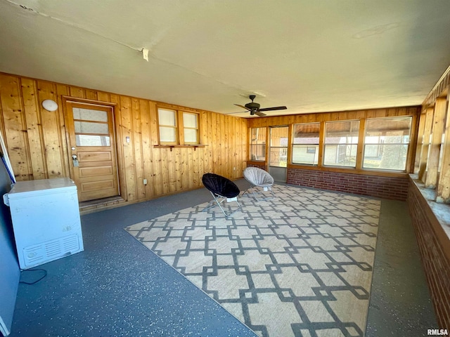 unfurnished sunroom featuring ceiling fan