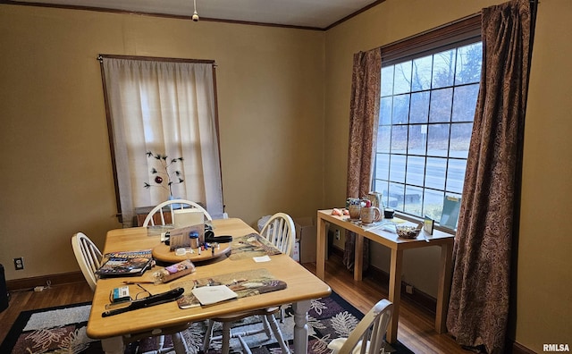 dining space featuring dark wood-type flooring, a wealth of natural light, and ornamental molding