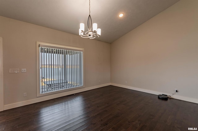 empty room with dark hardwood / wood-style flooring, an inviting chandelier, and vaulted ceiling