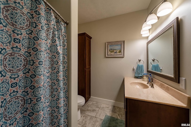 bathroom with tile flooring, toilet, and vanity