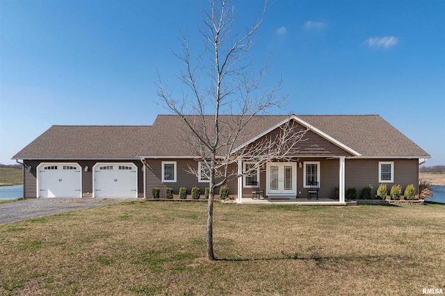 ranch-style house featuring a porch, a front lawn, and a garage