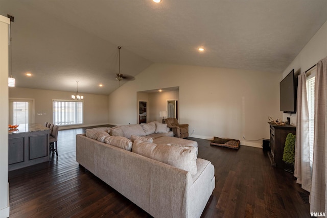 living room featuring dark hardwood / wood-style flooring, lofted ceiling, and ceiling fan with notable chandelier