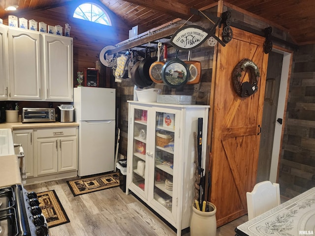 kitchen featuring wooden walls, lofted ceiling with beams, light hardwood / wood-style flooring, white fridge, and wood ceiling