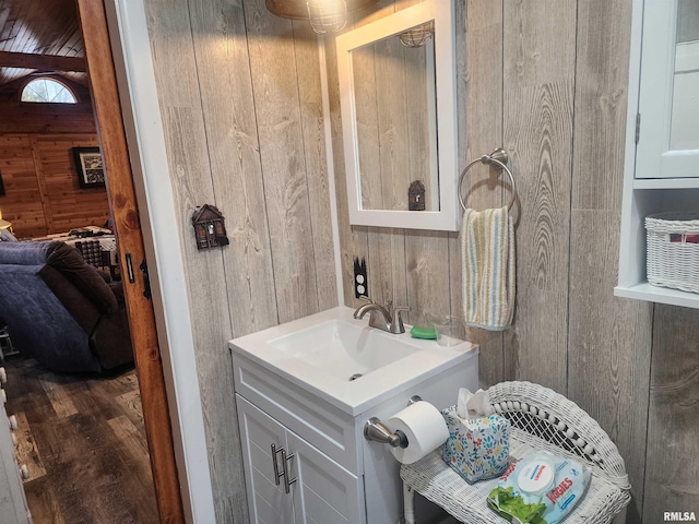 bathroom featuring wooden walls, hardwood / wood-style flooring, and large vanity