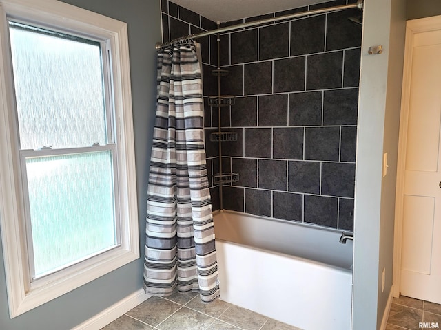 bathroom with shower / bath combo with shower curtain and tile patterned flooring