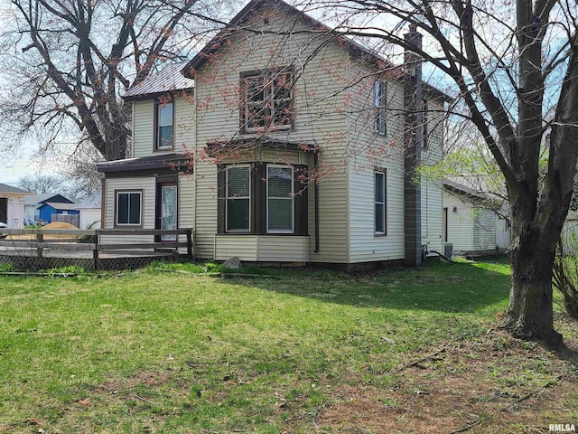 rear view of property featuring a yard