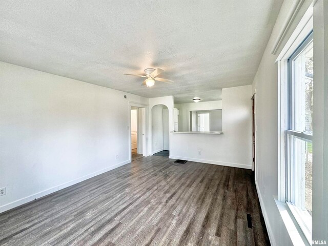 unfurnished living room featuring a textured ceiling, dark hardwood / wood-style floors, and ceiling fan