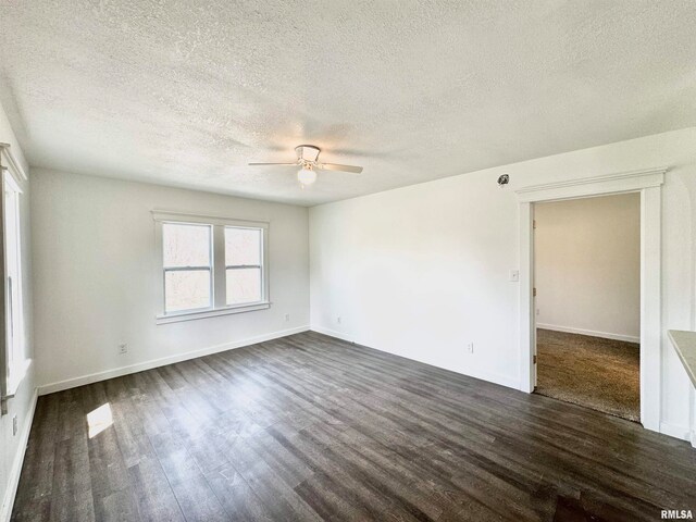 empty room featuring a textured ceiling, ceiling fan, and dark wood-type flooring