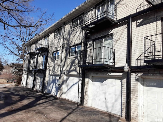 view of side of home with a garage and a balcony