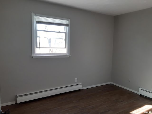 unfurnished room featuring a baseboard heating unit and dark wood-type flooring