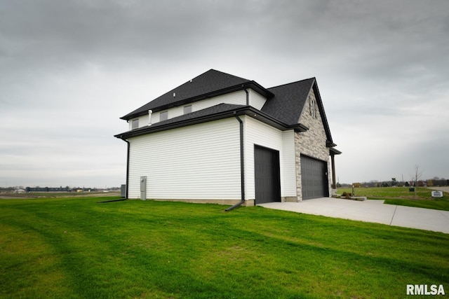 view of side of property with a yard and a garage