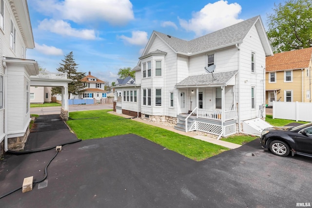 exterior space with covered porch and a front yard