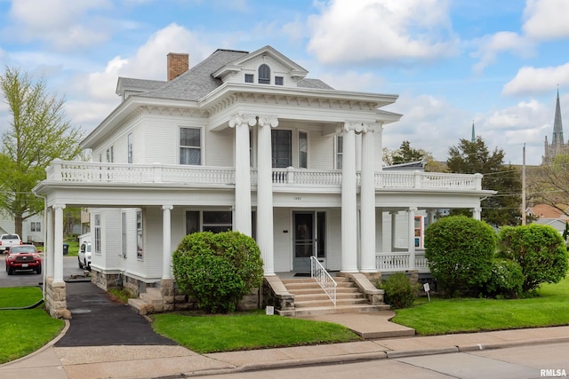 greek revival inspired property with a porch and a balcony