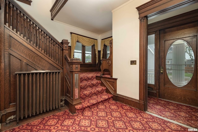 foyer entrance with crown molding and radiator