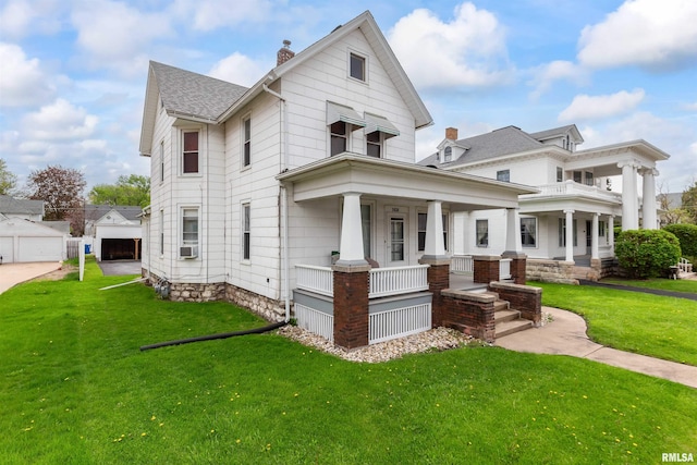 view of front of house with covered porch, a garage, and a front lawn