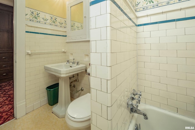 bathroom with tile floors, tile walls, tiled shower / bath combo, and toilet