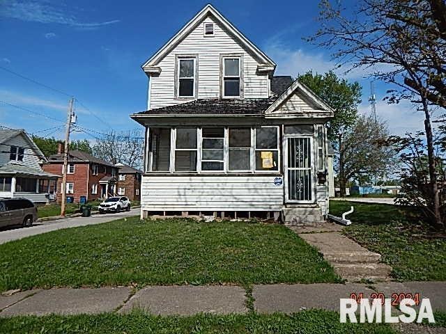 view of front of property with a sunroom and a front yard