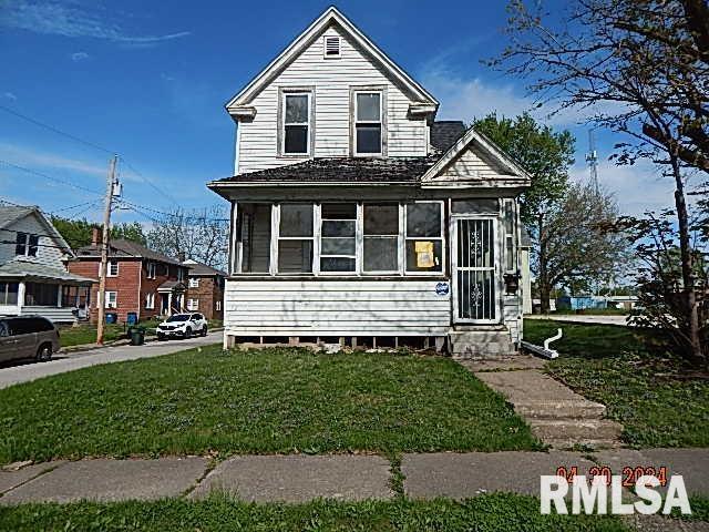 view of front of property with a sunroom and a front yard