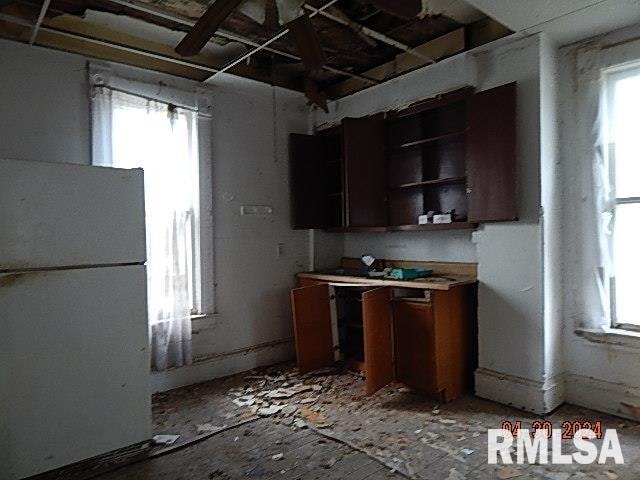 kitchen with open shelves, plenty of natural light, light countertops, and freestanding refrigerator