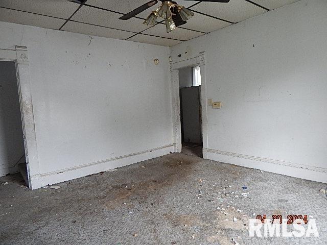 empty room featuring a paneled ceiling and ceiling fan