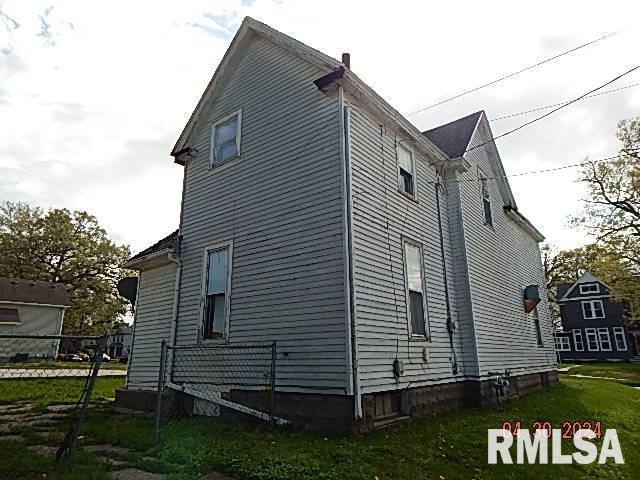 view of side of home with a yard