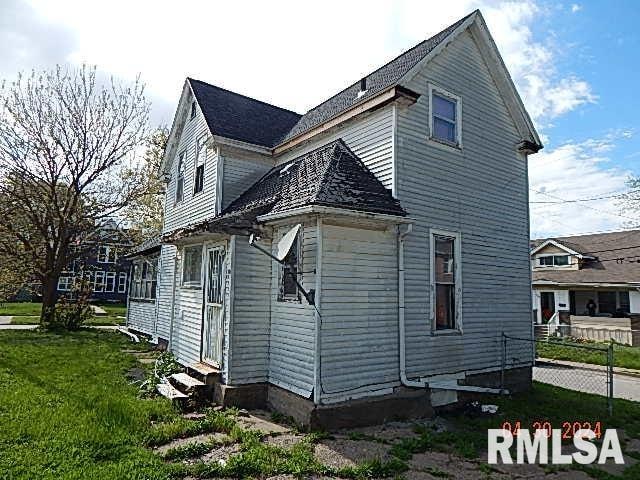 view of side of property with entry steps and a lawn