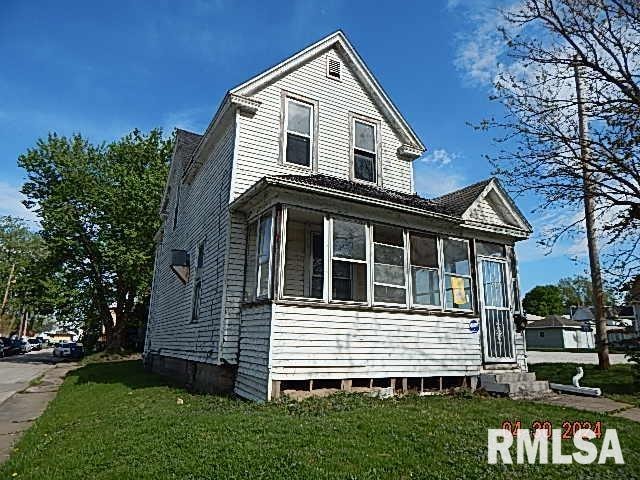 view of front facade with entry steps, a front yard, and a sunroom